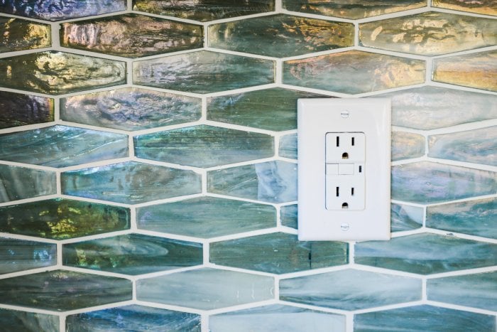 GFCI outlet on a glass tile wall